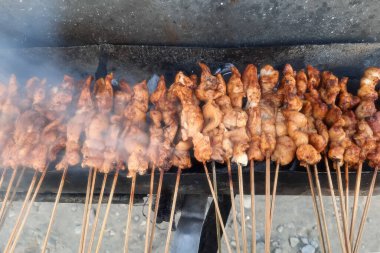 Izgaradaki tavuğun üst açılı görüntüsü. Baharatlı tavuk ızgarada ve fıstık sosuyla servis ediliyor..