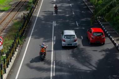 Surabaya, Endonezya - 18 Kasım 2021: Motosiklet ve Surabaya Indoenesia 'da Ahmad Yani caddesinden geçen arabalar. İnsanlar çalışmaya gidiyor.