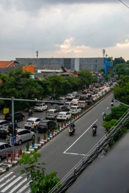Surabaya, Endonezya - 18 Kasım 2021: Endonezya 'daki Jemur Andayi caddesinde trafik sıkışıklığı yaşayan arabalar ve motosikletler. kuyrukta arabalar