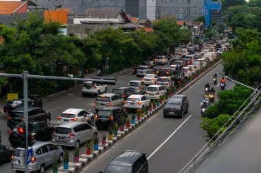 Surabaya, Endonezya - 18 Kasım 2021: Endonezya 'daki Jemur Andayi caddesinde trafik sıkışıklığı yaşayan arabalar ve motosikletler. kuyrukta arabalar