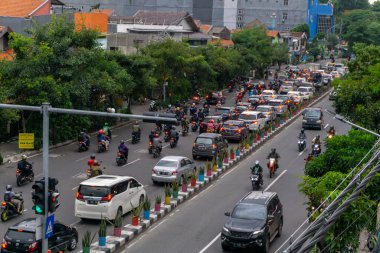 Surabaya, Endonezya - 18 Kasım 2021: Endonezya 'daki Jemur Andayi caddesinde trafik sıkışıklığı yaşayan arabalar ve motosikletler. kuyrukta arabalar