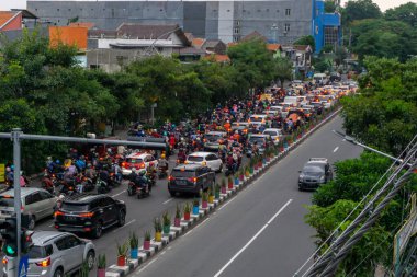 Surabaya, Endonezya - 18 Kasım 2021: Endonezya 'daki Jemur Andayi caddesinde trafik sıkışıklığı yaşayan arabalar ve motosikletler. kuyrukta arabalar