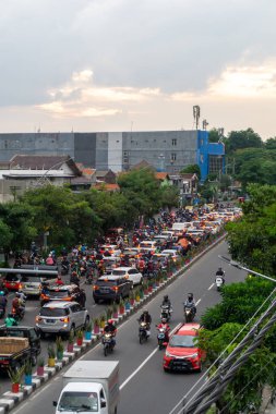 Surabaya, Endonezya - 18 Kasım 2021: Endonezya 'daki Jemur Andayi caddesinde trafik sıkışıklığı yaşayan arabalar ve motosikletler. kuyrukta arabalar