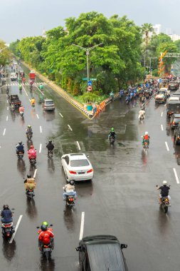 Surabaya, Endonezya - 18 Kasım 2021: Endonezya 'daki Darmo Caddesi' nden arabalar ve motosikletler geçiyor. Yağmurdan sonra ıslak sokak