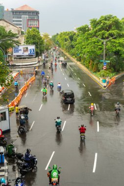 Surabaya, Endonezya - 18 Kasım 2021: Endonezya 'daki Darmo Caddesi' nden arabalar ve motosikletler geçiyor. Yağmurdan sonra ıslak sokak