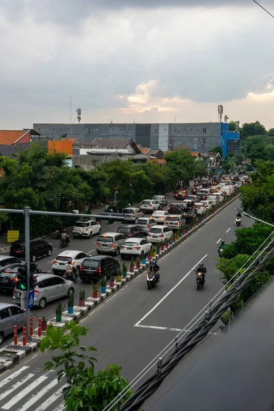 Surabaya, Endonezya - 18 Kasım 2021: Endonezya 'daki Jemur Andayi caddesinde trafik sıkışıklığı yaşayan arabalar ve motosikletler. kuyrukta arabalar
