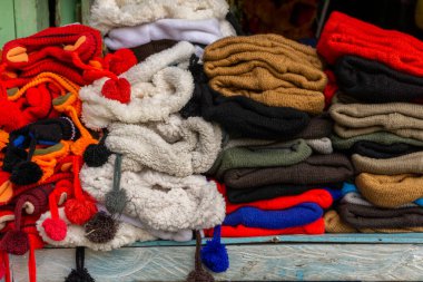 Yerel markette satılan renkli şapka yığınları. Kışlık kıyafetler için yün şapkalar. Örgü şapka.