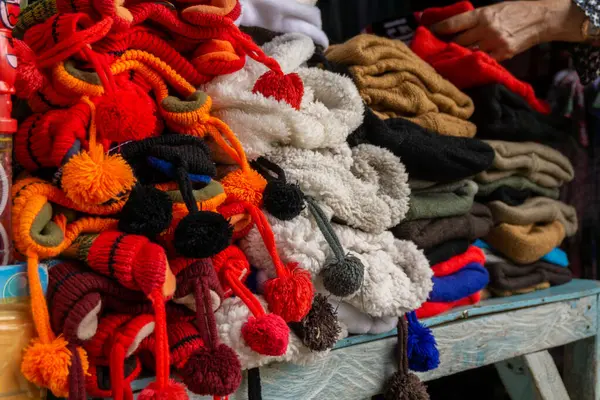Stacked of colorful beanie hats sells at local market. Wool hats for winter clothes. Knitted hat