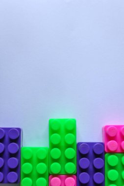Beyaz arkaplandaki lego tuğlalarının üst açı görüntüsü. kopyalama alanı. İçerik veya metin için yeri olan renkli Lego blokları yığını