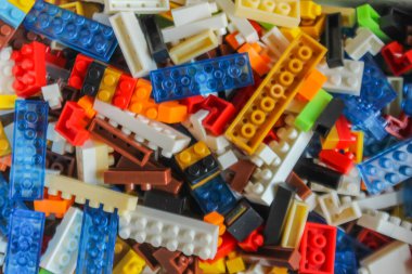 Beyaz arkaplandaki lego tuğlalarının üst açı görüntüsü. Renkli lego blokları yığını