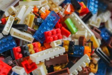 Beyaz arkaplandaki lego tuğlalarının üst açı görüntüsü. Renkli lego blokları yığını