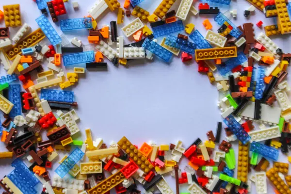 Beyaz arkaplandaki lego tuğlalarının üst açı görüntüsü. kopyalama alanı. İçerik veya metin için yeri olan renkli Lego blokları yığını