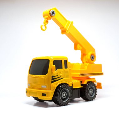 Temiz beyaz arka planda sergilenen parlak sarı oyuncak bir kamyonet..