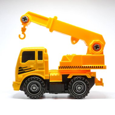 Temiz beyaz arka planda sergilenen parlak sarı oyuncak bir kamyonet..