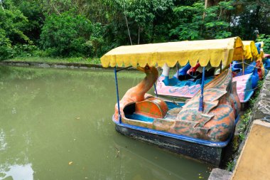 Göle parketmiş ördek pedallı tekne. Surabaya, Endonezya 'daki yapay gölde renkli süs botu..