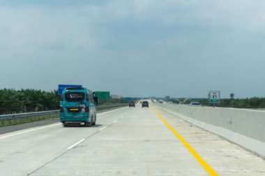 Medan, Endonezya - 6 Mayıs 2024: Tol Trans Sumatera adı verilen otoyol ve çevre yolundan geçen araba