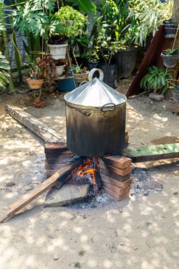 Asian traditional method of cooking. Boiling food with steam boiler and using fire woods.  clipart