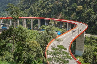 Payakumbuh, Endonezya - 13 Ağustos 2024: Batı Sumatera 'daki Doğu Payakumbuh City' de yer alan Kelok 9 adlı ünlü viraj yolundan geçen araba ve kamyon