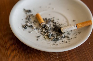Kül tablası ve kırık sigarayla yakın plan.