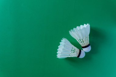 Badminton raketleri ve yeşil arka planda mekik taşakları. Boşluğu kopyala