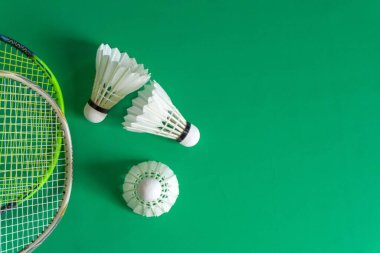 Badminton rackets and shuttlecocks on green background. copy space