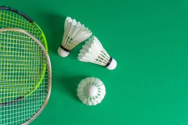 Badminton rackets and shuttlecocks on green background. copy space clipart