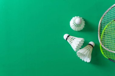 Badminton raketleri ve yeşil arka planda mekik taşakları. Boşluğu kopyala