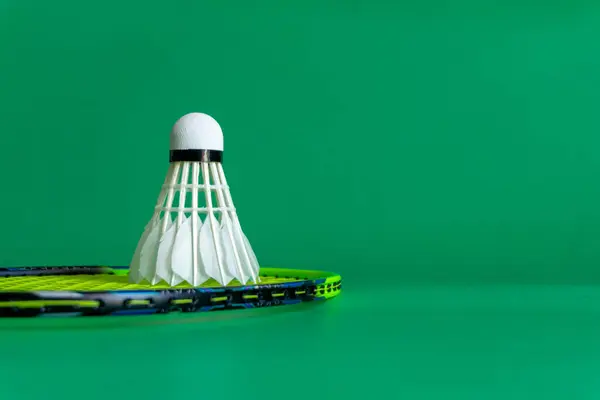 Badminton raketleri ve yeşil arka planda mekik taşakları. Boşluğu kopyala