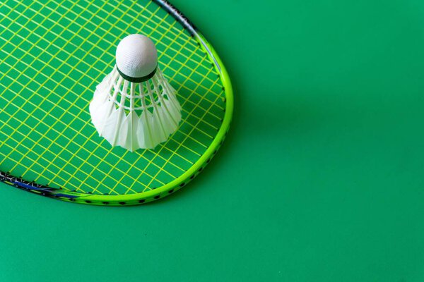 Badminton rackets and shuttlecocks on green background. copy space