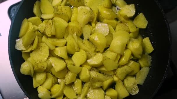 上ビュー黒コショウで揚げジャガイモを調理します 鍋にジャガイモを皮をむいた バターで揚げたジャガイモを食欲をそそる — ストック動画
