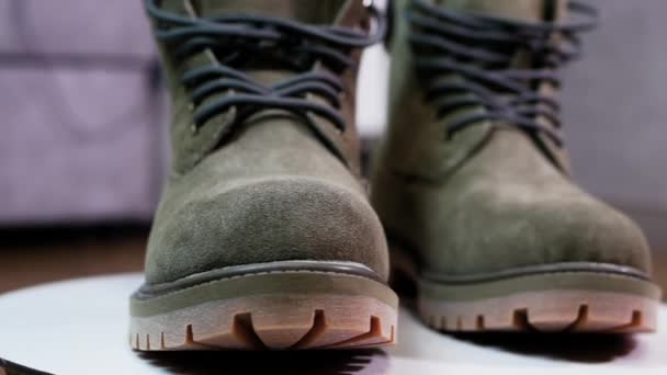 特写360号转盘上的男鞋橄榄色 男用皮鞋保暖靴 时髦的靴子 — 图库视频影像