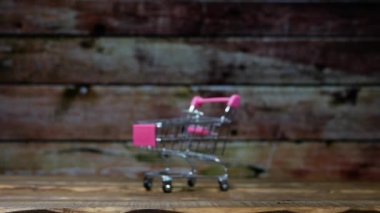 Ahşap bir arka planda süpermarketten alınmış bir arabada tavuk yumurtası. Marketten alınmış sepetteki tavuk yumurtaları stop motion animasyonu