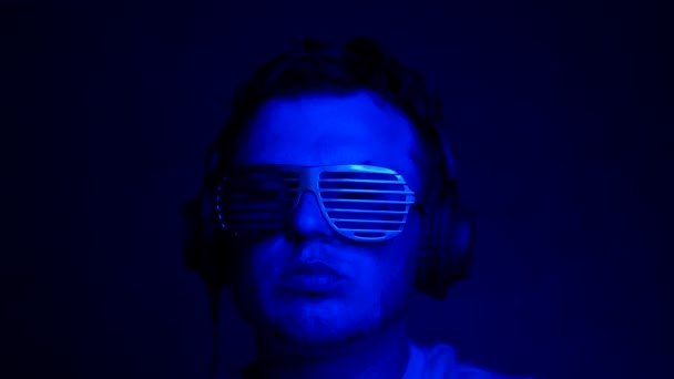 Háttérzene Neonban Egy Fülhallgatós Kreatív Klubszemüveges Férfival Egy Fiatalember Zenét — Stock videók