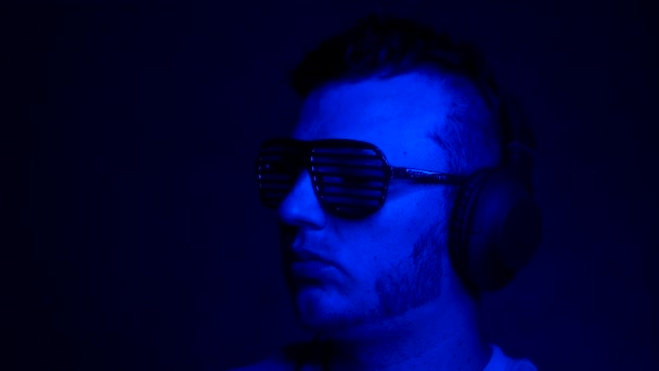 Piękne Muzyczne Tło Tańczącym Mężczyzną Słuchawkach Niebieskim Neonowym Tle Portret — Wideo stockowe