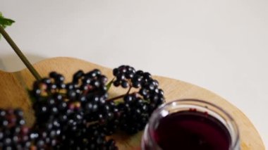 Tahtada doğal böğürtlen suyu, böğürtlen homeopati, kavanozda balsam olan mürver dalı..