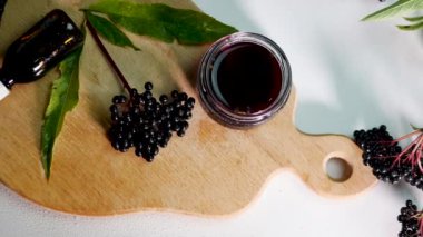 Kavanozdaki kırmızı böğürtlen tentürünün üst görüntüsü. Mürver suyu, şifalı böğürtlen