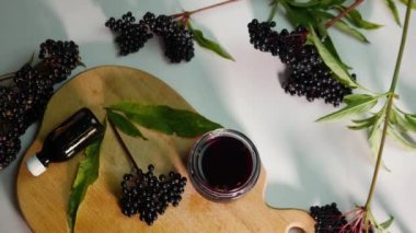 Üst manzara. Tahtadaki böğürtlenli doğal meyve suyu, böğürtlenli homeopati, kavanozda balsam olan mürver dalı..