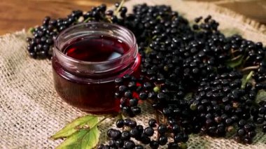  Yakın plan Doğal Yaşlı Meyve Suyu. Ahşap bir arka planda siyah mürver. Bitkisel ilaçlar. Homeopati, eski bir masada kara dut.