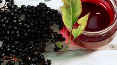 Tahta bir masada kavanozda taze meyve suyu. Sıkılmış mürver suyu. Likörlü siyah böğürtlen.