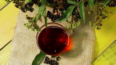 Taze böğürtlenlerden gelen kırmızı çay, ahşap bir masanın üst manzarasında. Mürver çayı. C vitamini ve doğal çay. Sağlık için bitki çayı. Homeopati. Sambuca çileği.