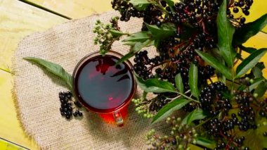 Kırmızı böğürtlen çayını yakın planda, ahşap bir masanın üst manzarasında. Mürver çayı. Vitaminler ve doğal çay. Sağlık için bitki çayı.