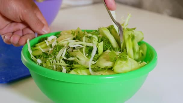 一个男人用勺子搅拌新鲜黄瓜 煮绿色沙拉 盘子里的新鲜蔬菜 — 图库视频影像