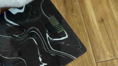 İnsan ağırlık kontrolü, gri çoraplı erkek bacakları zemin terazisinde durur, 82.7 kg 'lık insan, obezite ve aşırı kilolu bir insan.