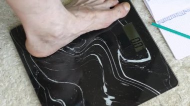 İnsan ağırlığı kontrolü, erkek yaşlı bacakları zemin ölçeğinde duruyor, 68.8 kg 'lık insan, obezite ve aşırı kilolu bir insan.