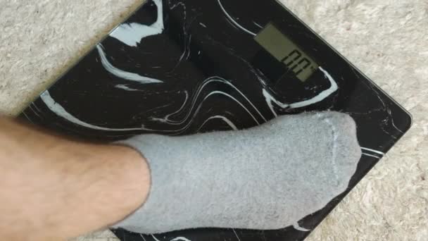 一个人的体重控制 穿着灰色袜子的男性双腿站在地板上 77公斤人 肥胖和超重 — 图库视频影像
