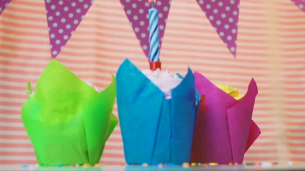キャンドルを燃やすと幸せな誕生日マルチカラーマフィン ピンクの女の子のためにおめでとうございます ケーキや休日の装飾と美しいお祝いの背景 — ストック動画