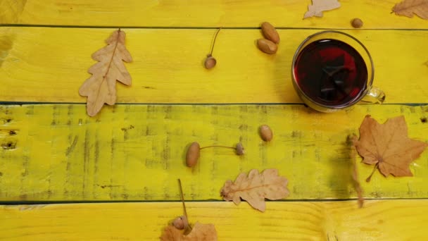 Goldener Herbsthintergrund Mit Laub Und Einem Becher Roten Tees Auf — Stockvideo