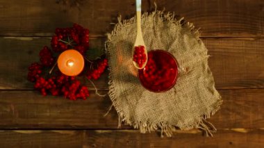  Sıcak çaya kırmızı viburnum çileği dök. Böğürtlene dayalı sağlıklı naturopati ya da homeopati için güzel kokulu çay. Masada çay varken mum yanar. Dolaşım sağlığı için iç