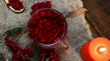 Üst manzara ağır çekim kırmızı çay fincanda sıcak, viburum olgun meyveli çay. Naturopati içeceği. Antioksidan çilek çayı. Homeopati tıbbi sıvısı.