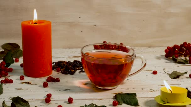 Κοντινό Φλιτζάνι Κόκκινο Τσάι Και Αναμμένα Κεριά Λευκό Ξύλινο Τραπέζι — Αρχείο Βίντεο